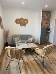 uma sala de estar com um sofá, uma mesa e cadeiras em Appartement vue Port em Perros-Guirec