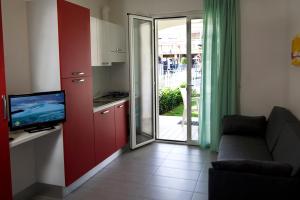 ein Wohnzimmer mit einem Sofa und eine Küche mit einer Glasschiebetür in der Unterkunft Residence Blumare in Martinsicuro