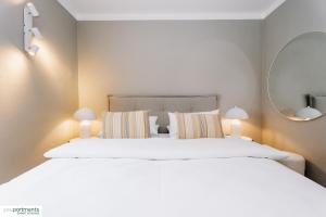 a bedroom with a large white bed and a mirror at YOUPARTMENTS - zentrale Micro Apartments in Kaiserslautern