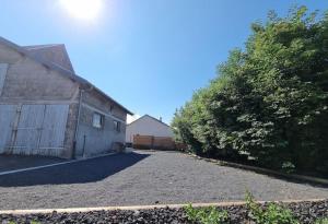 a driveway in front of a house with a garage at Gîte 6 personnes Chez Max in Nébouzat