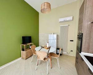 a dining room with green walls and a table and chairs at Chicco di Grano in Locorotondo