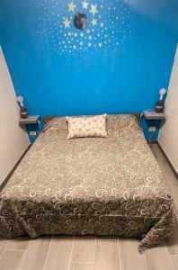 una camera da letto con un letto con una parete blu di Tiny Beautiful Thing Ragusa a Ragusa