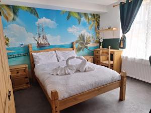 a bedroom with a bed with a mural of a ship at Sunny Waves in Northampton