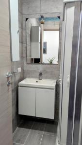 un bagno con un lavandino bianco e uno specchio di Tiny Beautiful Thing Ragusa a Ragusa Altre 22 foto