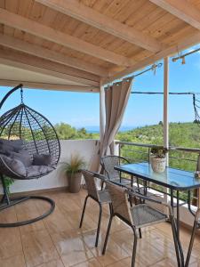 a patio with a table and chairs and a swing at Ortensia in Oziás