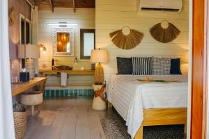 una camera da letto con un letto e un bagno con un lavandino di Tranquilseas Eco Lodge & Dive Center a Sandy Bay