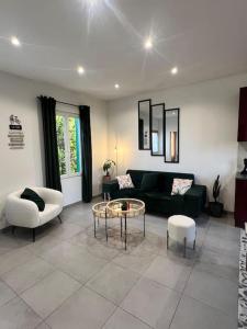 a living room with a couch and a table and chairs at Maison avec jardin, jacuzzi entre Paris et Disney in Champigny-sur-Marne