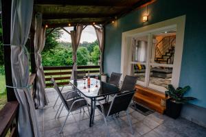 a dining room with a table and chairs and a window at Jenny vendégház in Zalakaros