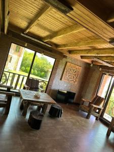 une grande pièce avec une table et des chaises en bois dans l'établissement Guest house and cellar MAMULI, à Tʼerjola