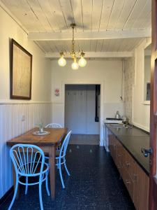 una cucina con tavolo e sedie in legno di Departamento Céntrico 3 a El Bolsón