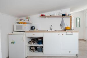 a kitchen with white cabinets and a sink at Apartment Tom in Starigrad-Paklenica +11 photos