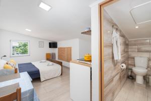 a bedroom with a bed and a bathroom with a toilet at Apartment Tom in Starigrad-Paklenica