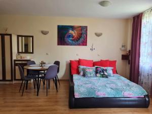 a bedroom with a bed and a table with chairs at Апартаменти-Студия в Комплекс Нестинарка in Tsarevo