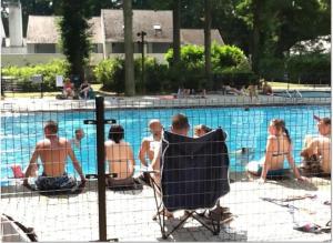 a group of people sitting around a swimming pool at Studio Ceder 1 in Houthalen-Helchteren