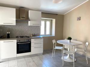 a kitchen with white cabinets and a table and chairs at Armonia House in Isernia