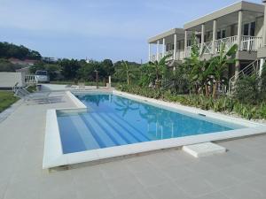 a large swimming pool in front of a building at Passion Village Apartments by Antigua Living in Jolly Harbour