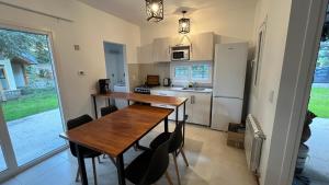 a small kitchen with a wooden table and chairs at Epu Way in Villa La Angostura