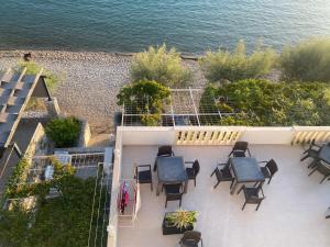 a balcony with chairs and tables and the ocean at Villa Ante Apartments in Blace