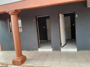 a row of three doors in a building with a pillar at Letz Guest Lodge in Tolwe