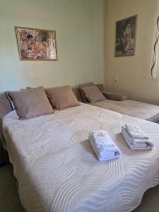- un grand lit blanc avec 2 serviettes dans l'établissement Marija Apartment br 1, à Bitola 1 autre photo