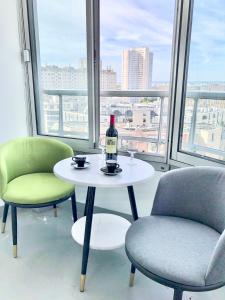 a table with a bottle of wine and two chairs at Chambre Lucas Salle de bain Privative in Paris