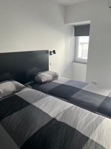 a bedroom with two beds and a window at H I Alojamento in Manteigas