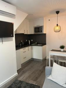 a small kitchen with white cabinets and a table at H I Alojamento in Manteigas +12 photos