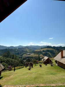 a view of a farm with mountains in the background at Pousada Vista do Paraíso in Monte Verde
