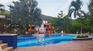 a large swimming pool with palm trees and a building at Apartasol San Jeronimo in San Jerónimo