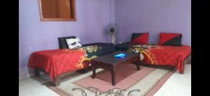 a room with two beds and a couch and a table at Appart paillote2 bou ismail in Bou Ismaïl