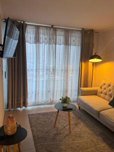 a living room with a couch and a large window at Arriendos Iquique G&P in Iquique