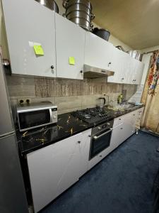 a kitchen with white cabinets and a black counter top at Rise Lodge in Brussels