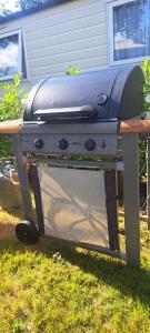 a grill sitting on a table in the grass at Nessy's Place (sta caravan) in Oude Willem