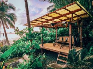 a wooden pergola with a table and a bench at Beachfront Private Bungalow in Libertad