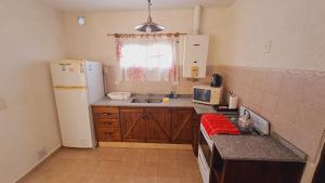 a small kitchen with a refrigerator and a sink at Roena Cabañas in Villa Giardino +43 photos