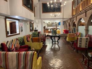 una hall con divani e sedie in un edificio di Terra Andina Colonial Mansion a Cuzco