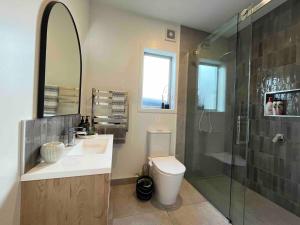 a bathroom with a sink and a shower and a toilet at Cozy Lakeside Oasis in Rotorua
