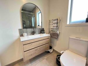 a bathroom with a sink and a mirror and a toilet at Cozy Lakeside Oasis in Rotorua +12 photos