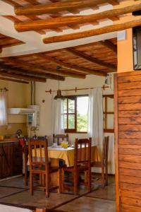 a kitchen with a table and chairs in a room at Roena Cabañas in Villa Giardino