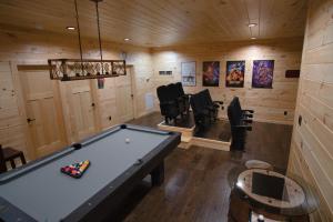 a billiard room with a pool table and chairs at Luxury Cabin, Mtn Views, Theater, Game Room, 4BR in Gatlinburg