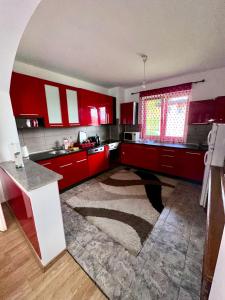 eine Küche mit roten Schränken und einem großen Teppich in der Unterkunft Apartment Panonija in Tuzla