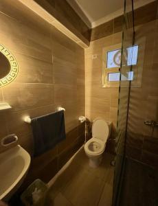 a bathroom with a toilet and a sink and a tub at Princess Resort Hurghada in Hurghada