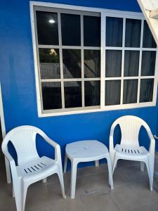 two white chairs and a table and a window at Casa Azul in Isla Mujeres +2 photos
