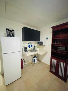 a kitchen with a white refrigerator and a counter at Casa Azul in Isla Mujeres