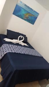 a blue bed with a pair of swans on it at Casa Azul in Isla Mujeres