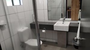 a bathroom with a toilet and a sink and a mirror at Tully Motel in Tully +53 photos