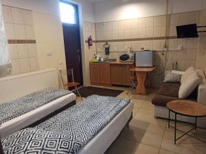 a room with two beds and a couch and a kitchen at Arkadia Noclegi in Łuków