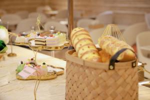 a table topped with a basket of pastries and cakes at Vienna International Hotel Jieyang Yangmei Jade hotel in Jieyang +55 photos