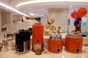 a chef preparing food in a restaurant with a buffet at Vienna International Hotel Jieyang Yangmei Jade hotel in Jieyang