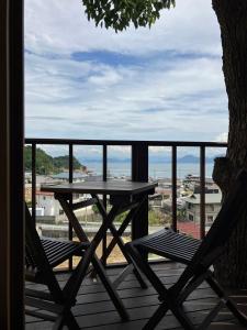 a table and two chairs on a deck with a view at MY LODGE Naoshima in Naoshima